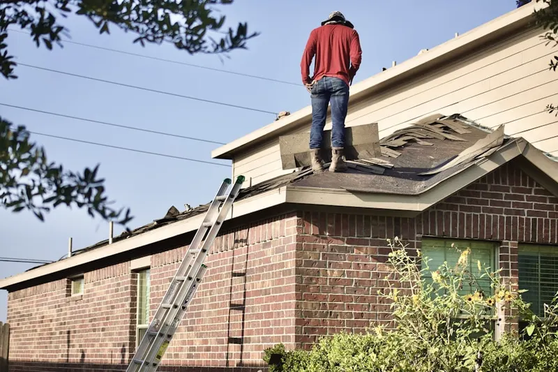 Professional roofer working on a residential roof in Murdock